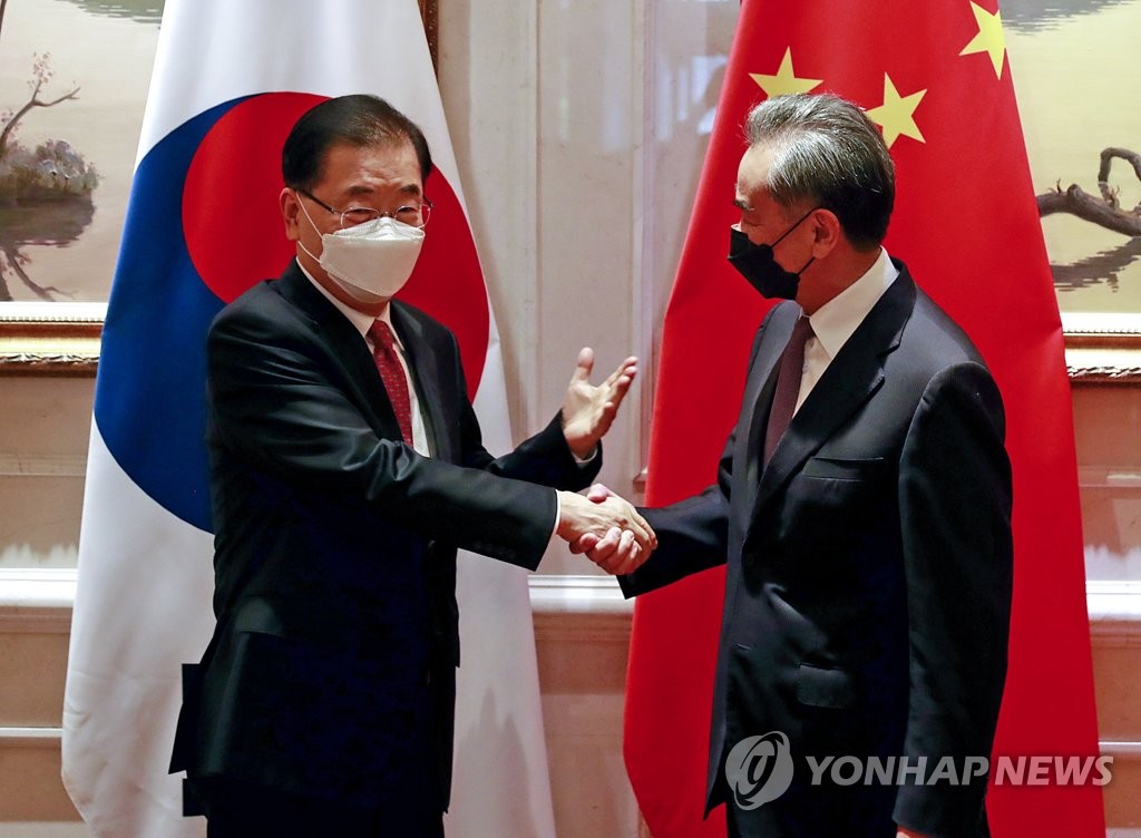 资料图片：2021年4月3日，在位于中国厦门的威海就断，韩国外交部长官郑义溶（左）和中国外交部长王毅握手致意。 韩联社