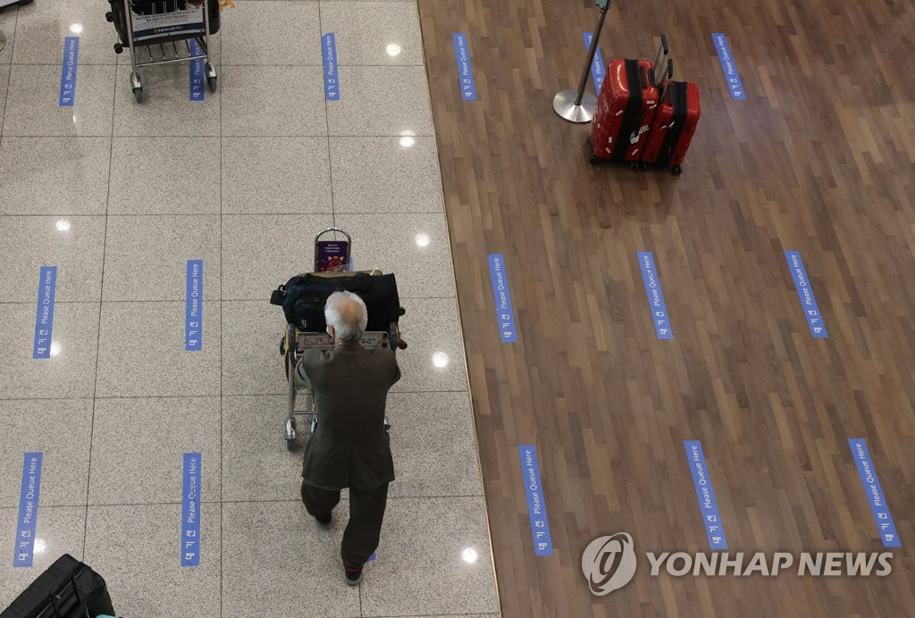 资料图片：在仁川机场，入境人员排队办理入境手续。 韩联社