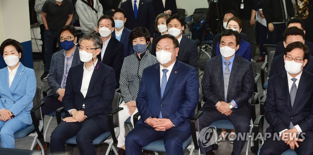 4月7日，在位于首尔汝矣岛的执政党共同民主党办公楼，该党党鞭兼代理党首金太年（前排左三）观看三大电视台出口民调结果。 韩联社