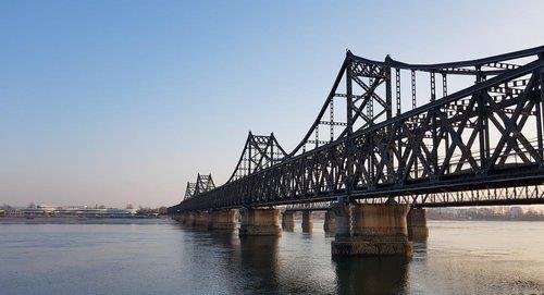 资料图片：从中国丹东瞭望的朝中边境桥梁和朝鲜新义州 韩联社