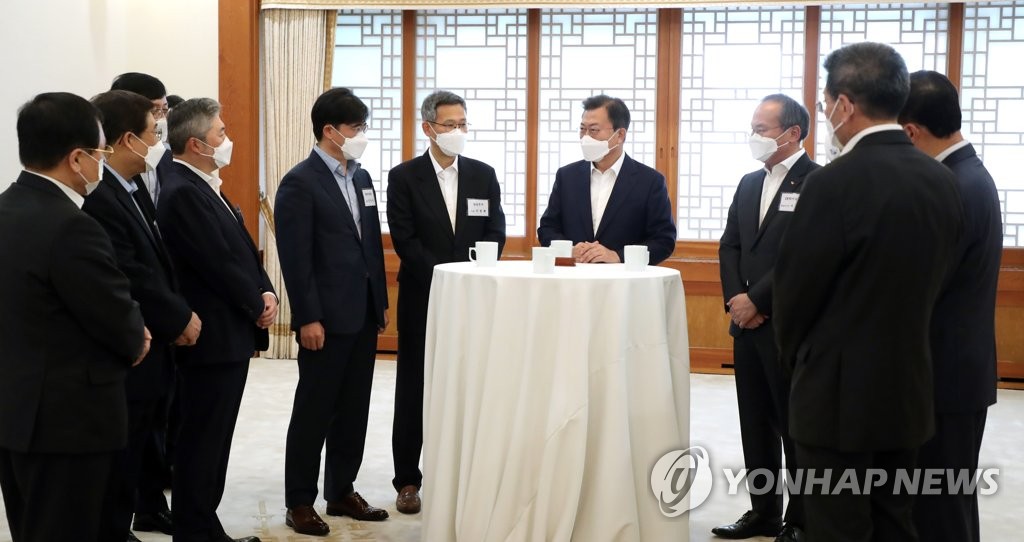 4月15日，在青瓦台，韩国总统文在寅（右四）在出席经济部长扩大会议之前同与会人员交谈。 韩联社