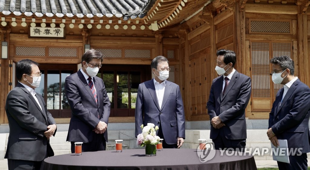 4月21日，在青瓦台，韩国总统文在寅（中）与首尔市长吴世勋（左四）和釜山市长朴亨埈（左二）共进午餐前交谈。 韩联社