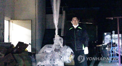 资料图片：韩国脱北者团体“自由北韩运动联合”代表朴相学与反朝传单合影。 韩联社/“自由北韩运动联合”提供视频截图（图片严禁转载复制）