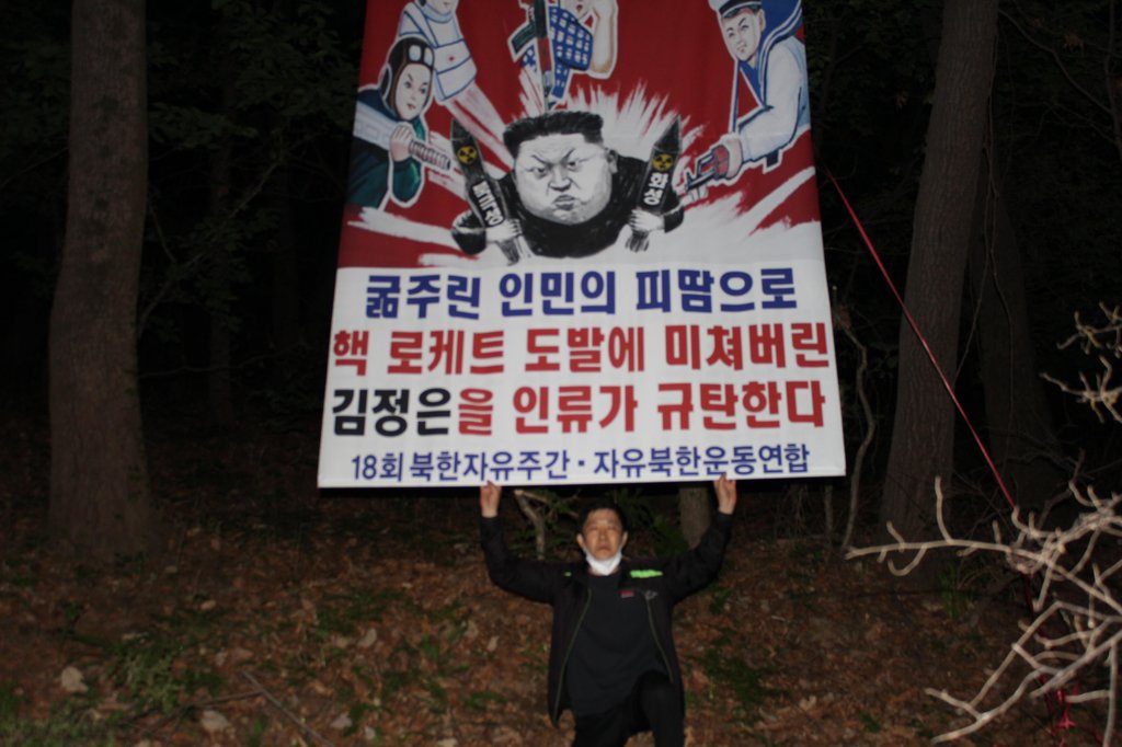 资料图片：“自由北韩运动联合”代表朴相学高举反朝标语。 “自由北韩运动联合”供图（图片严禁转载复制）