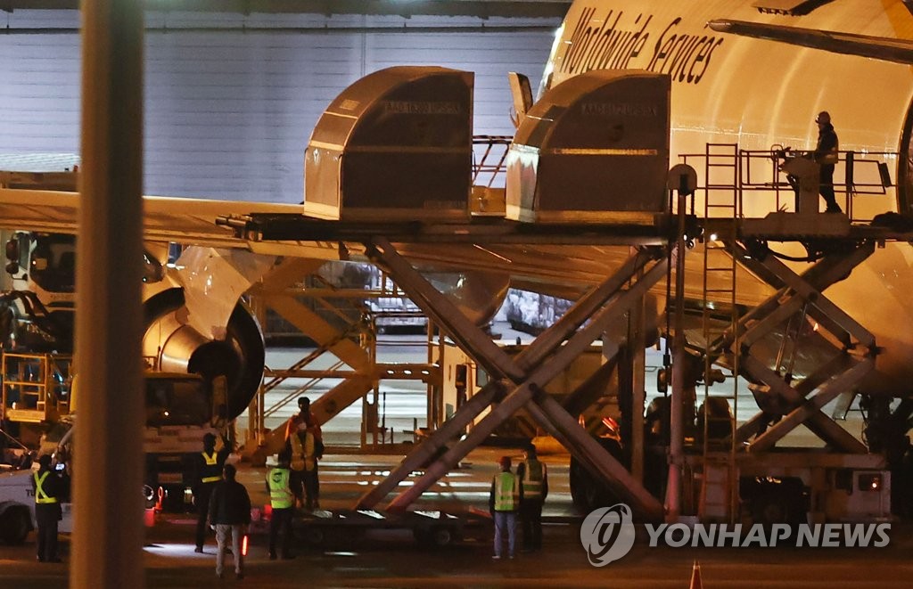 资料图片：5月5日凌晨，韩国政府向辉瑞公司直接采购的新冠疫苗中43.6万剂运抵仁川机场。图为工作人员从货机卸货。 韩联社