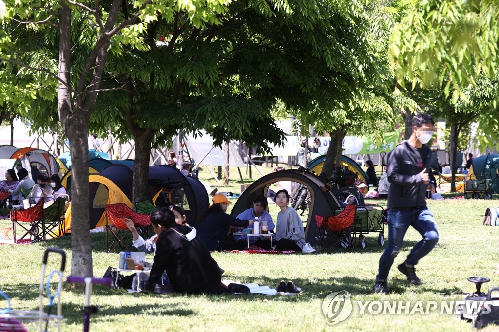 资料图片：在首尔汉江公园休息的市民 韩联社