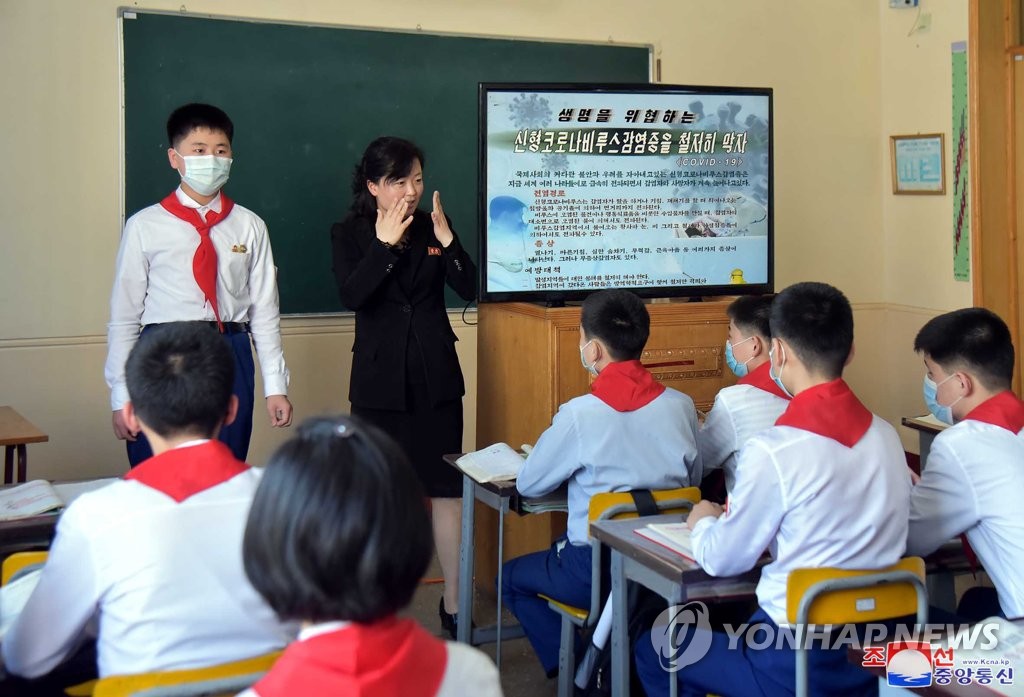 资料图片：在位于朝鲜平壤市的一所初中，教师向学生们普及防疫守则。 韩联社/朝中社（图片仅限韩国国内使用，严禁转载复制）