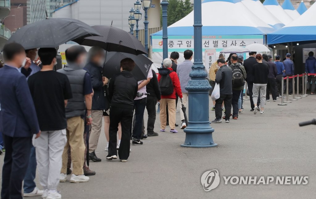 资料图片：5月20日，在首尔火车站广场的临时筛查诊所，市民排队接受病毒检测。 韩联社