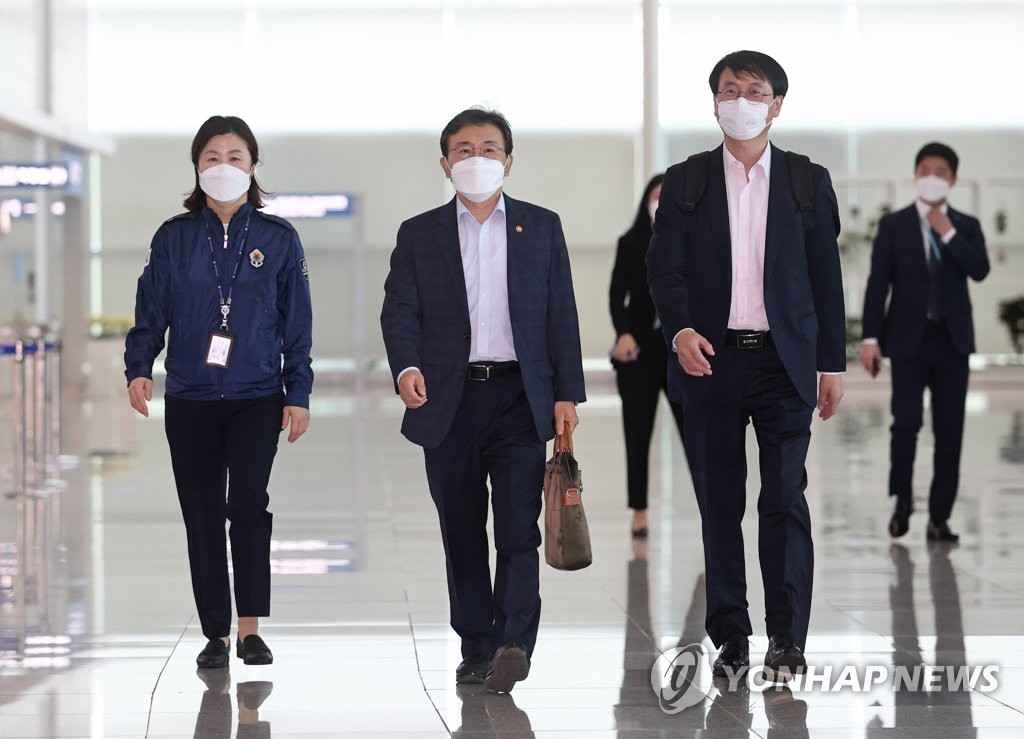 5月21日，在仁川国际机场第二航站楼，保健福祉部长官权德喆（居中）走向出境大厅。韩美卫生部长将于当地时间22日在美国举行会谈。 韩联社