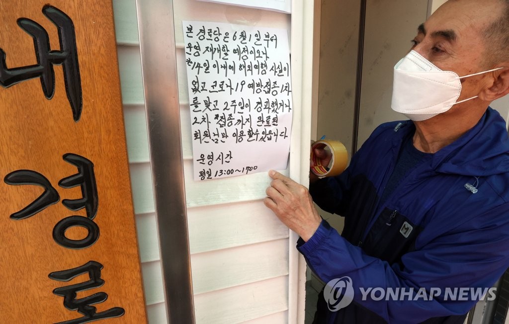 资料图片：5月31日，在首尔市九老区的一家老年人福利设施，管理人员贴关于首剂疫苗接种者奖励措施的通知。 韩联社