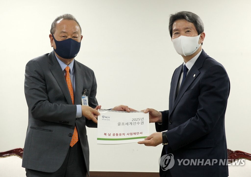6月4日下午，在中央政府首尔办公楼，李重明（左）向李仁荣传达关于韩朝申办2025年世界高尔夫锦标赛建议书。 韩联社
