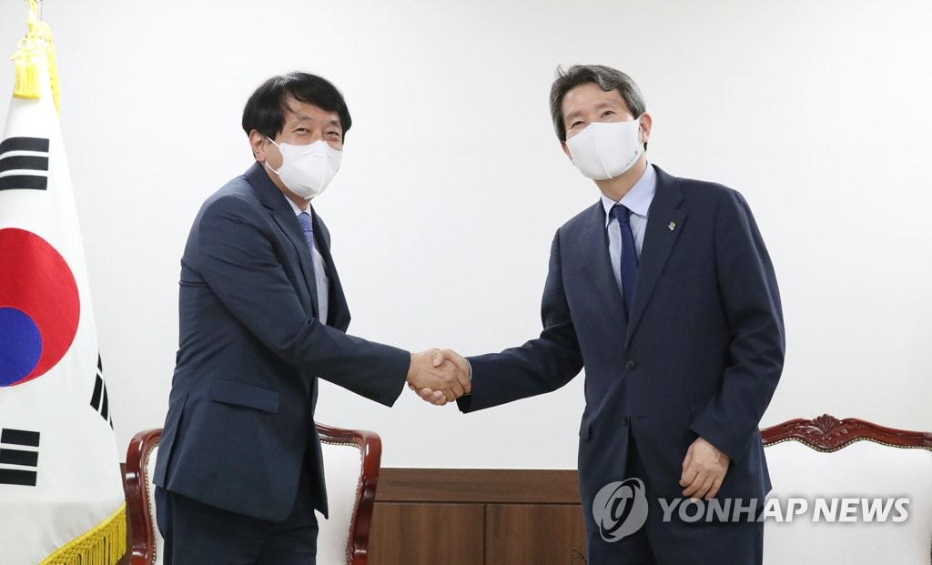 6月9日，在中央政府首尔办公楼，韩国统一部长官李仁荣（右）会见韩国观光公社社长安荣培。 韩联社/统一部供图（图片严禁转载复制）