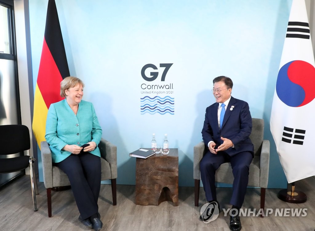 资料图片：当地时间6月12日，在英国，韩国总统文在寅（右）和德国总理默克尔举行会谈。 韩联社