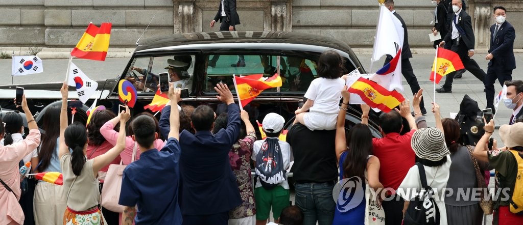 当地时间6月15日，在西班牙首都马德里，当地韩侨向韩国总统文在寅乘坐的车辆挥动太极旗表示欢迎。 韩联社
