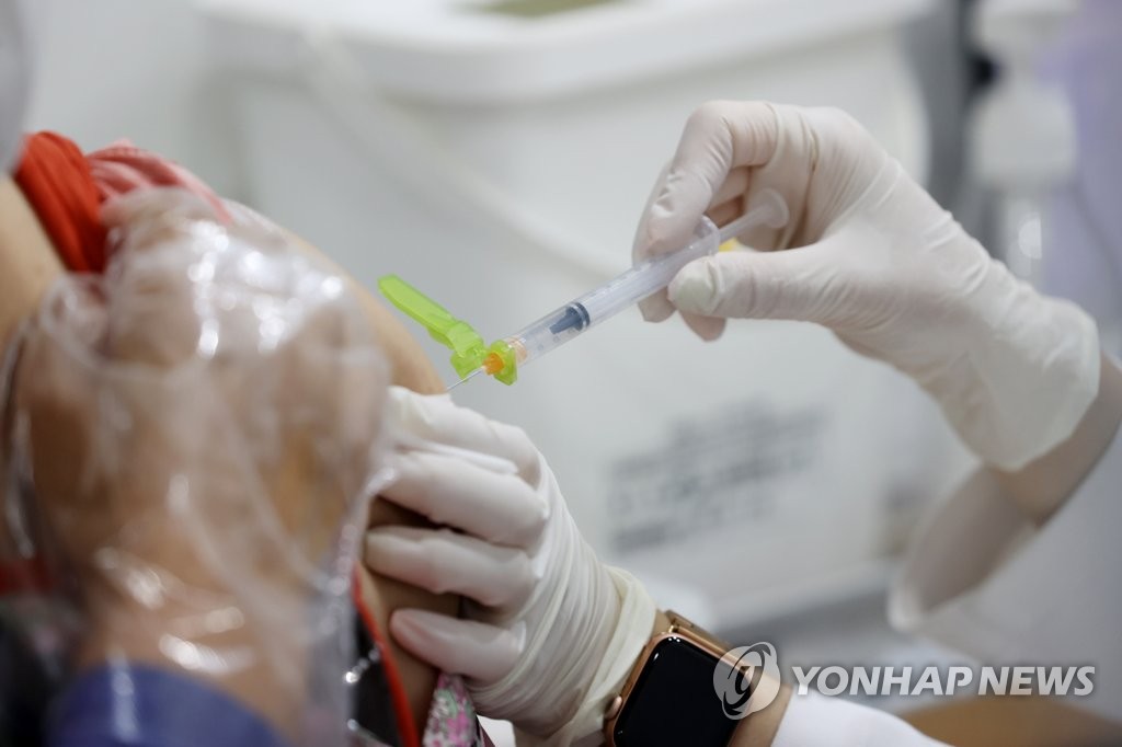 资料图片：6月17日，在设于首尔市永登浦区的一处新冠疫苗接种点，医务人员施打新冠疫苗。 韩联社
