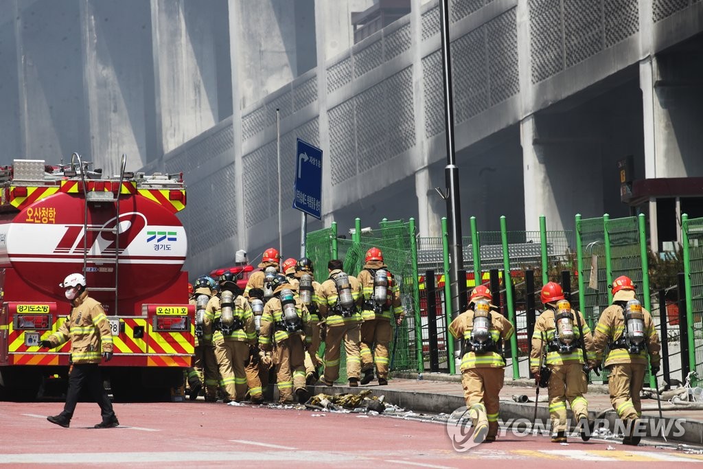 资料图片：6月20日上午，在京畿道利川市麻长面德坪分拣中心，消防员们匆忙赶赴火场。 韩联社