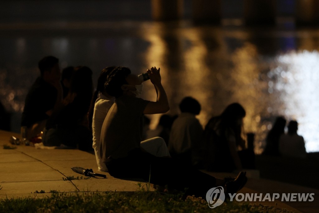 资料图片:7月4日晚,在首尔汉江公园,市民们在江边用餐饮酒 韩联社