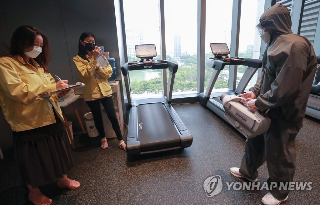 资料图片：7月6日下午，在首尔市松坡区乐天世界塔内的健身中心，防疫人员检查日常消杀工作。 韩联社