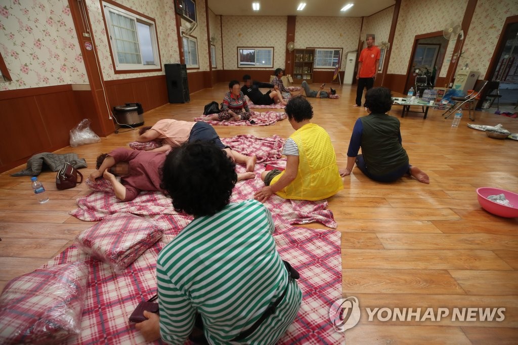 7月6日下午，在全罗南道长兴郡大德邑一处村民会馆，居民紧急离家避雨。 韩联社