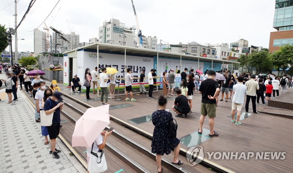 资料图片：7月7日，在首尔城北区的一处筛查诊所，市民排队等待接受新冠病毒检测。 韩联社