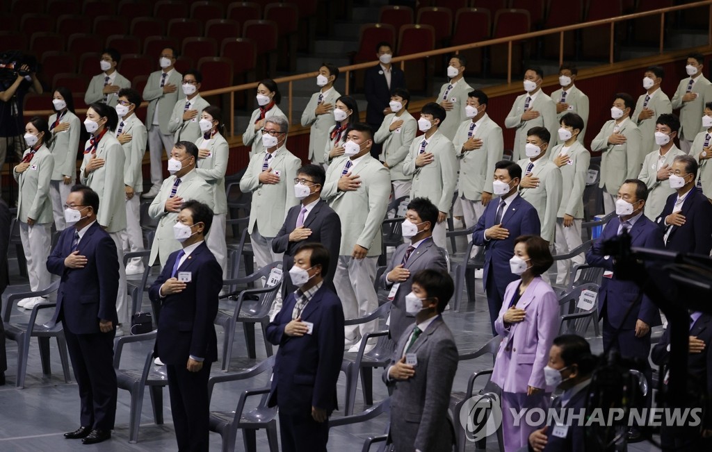 7月8日，在位于首尔市松坡区的奥林匹克公园奥林匹克大厅，东京奥运会韩国代表团成立仪式举行。图为韩国国务总理金富谦（前排左一）和运动员向国旗敬礼。 韩联社