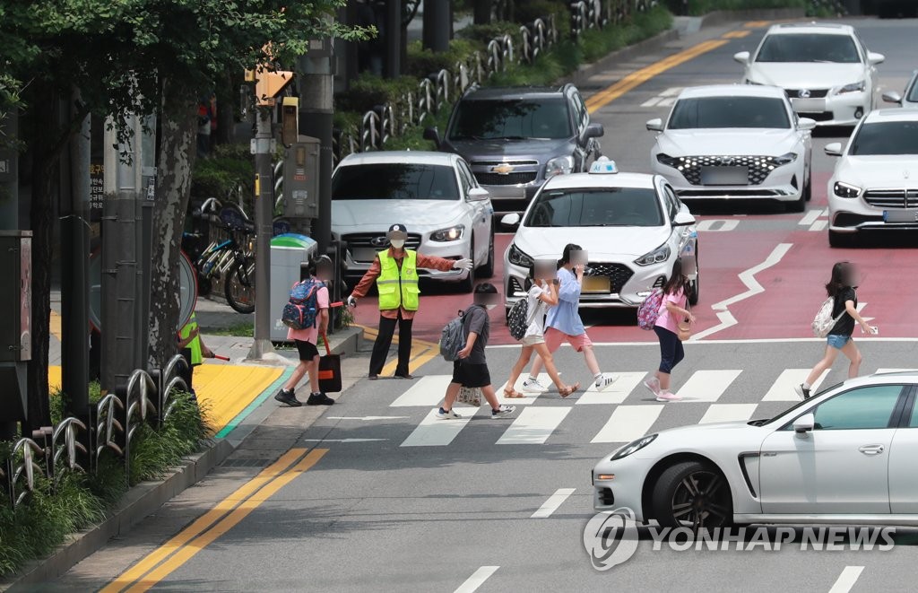 资料图片：学生们走在放学路上。 韩联社