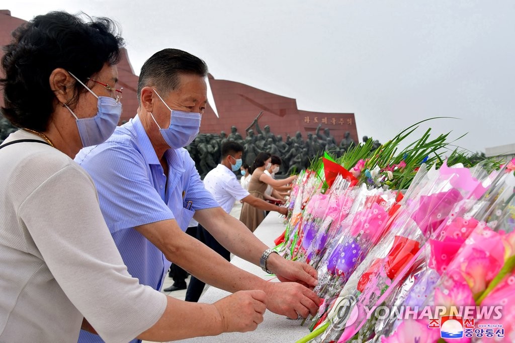 资料图片：朝鲜居民向朝鲜已故最高领导人金日成和已故国防委员长金正日的铜像献花。 韩联社