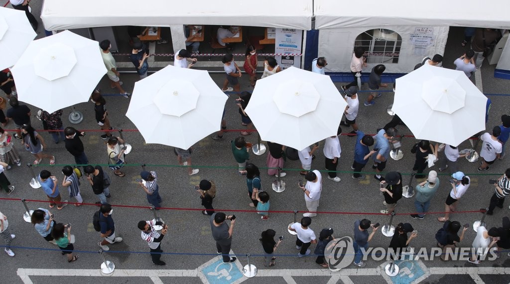 资料图片：7月14日，在设于首尔江南区卫生站的筛查诊所，市民排队等待接受病毒检测。 韩联社