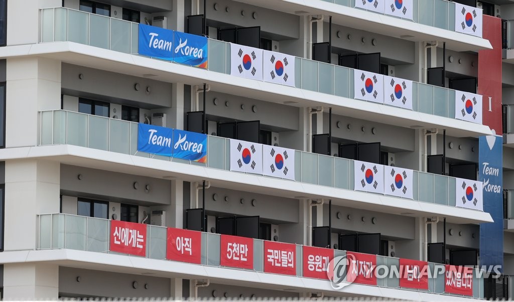 7月15日，在位于东京晴海的东京奥运村，韩国代表团住宿楼垂挂着韩国国旗和印有“臣还有5000万国民声援和支持”的加油横幅。 韩联社