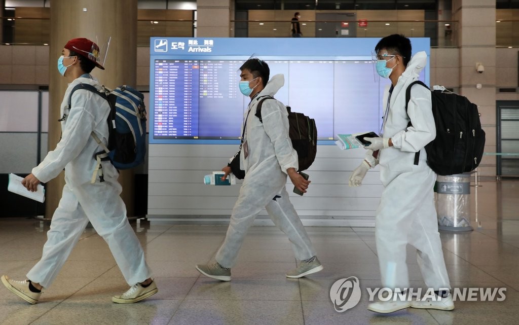 资料图片：穿防护服入境的外国人 韩联社