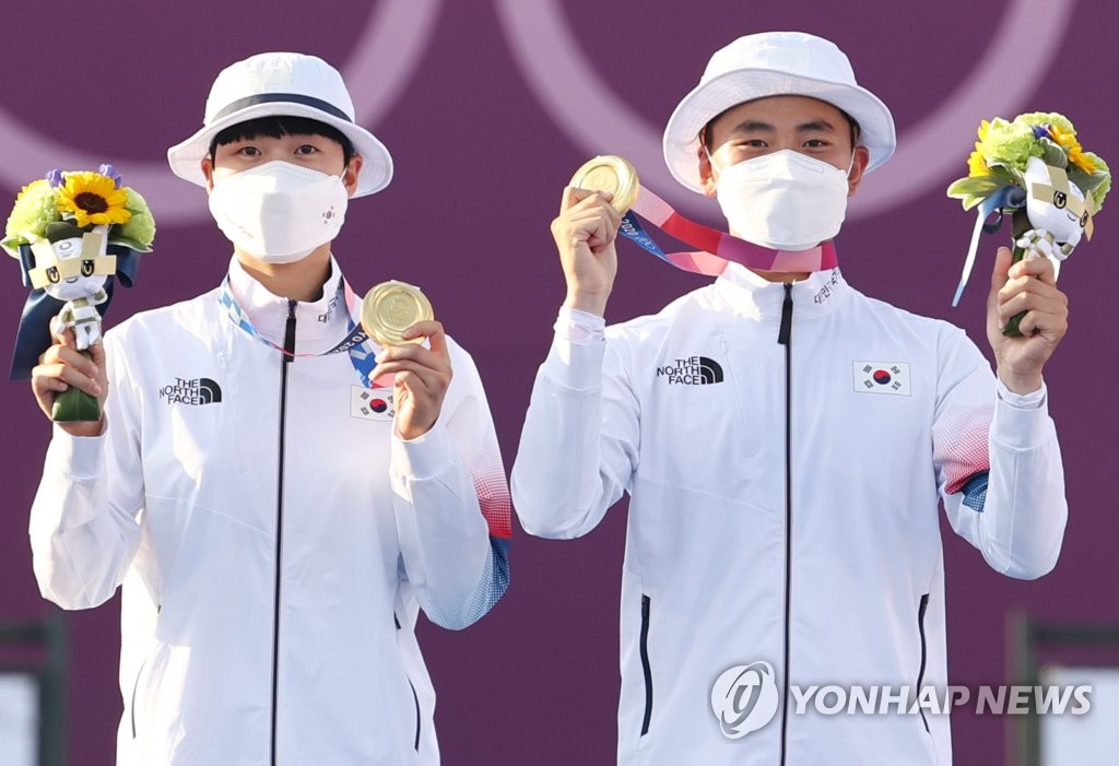 7月24日，在东京梦之岛公园，金济德（右）和安山举起金牌庆祝夺金。 韩联社