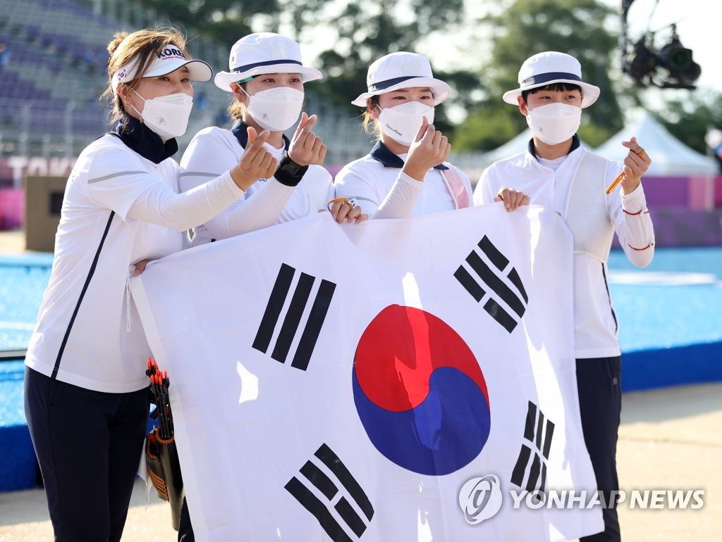 7月25日下午，在东京梦之岛公园，韩国女子射箭队获得团体赛金牌后摆姿势合影留念。 韩联社
