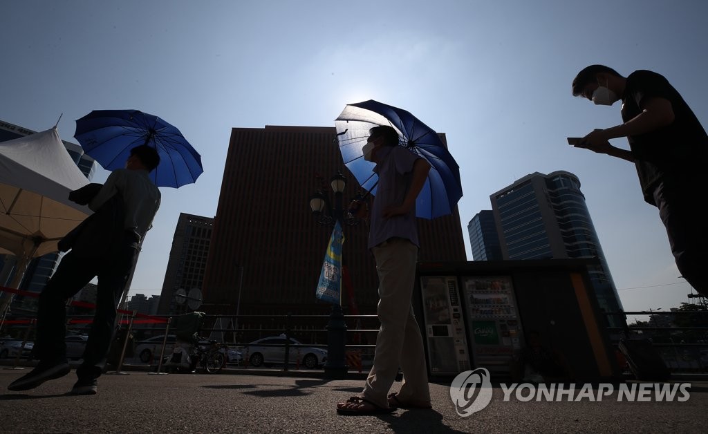 7月27日，在设于首尔站广场的临时筛查诊所，市民排队待检。 韩联社