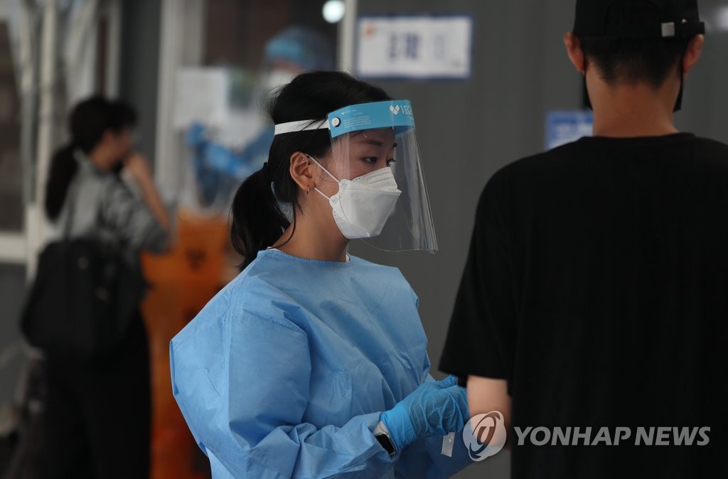 资料图片：一处临时筛查诊所的医务人员 韩联社