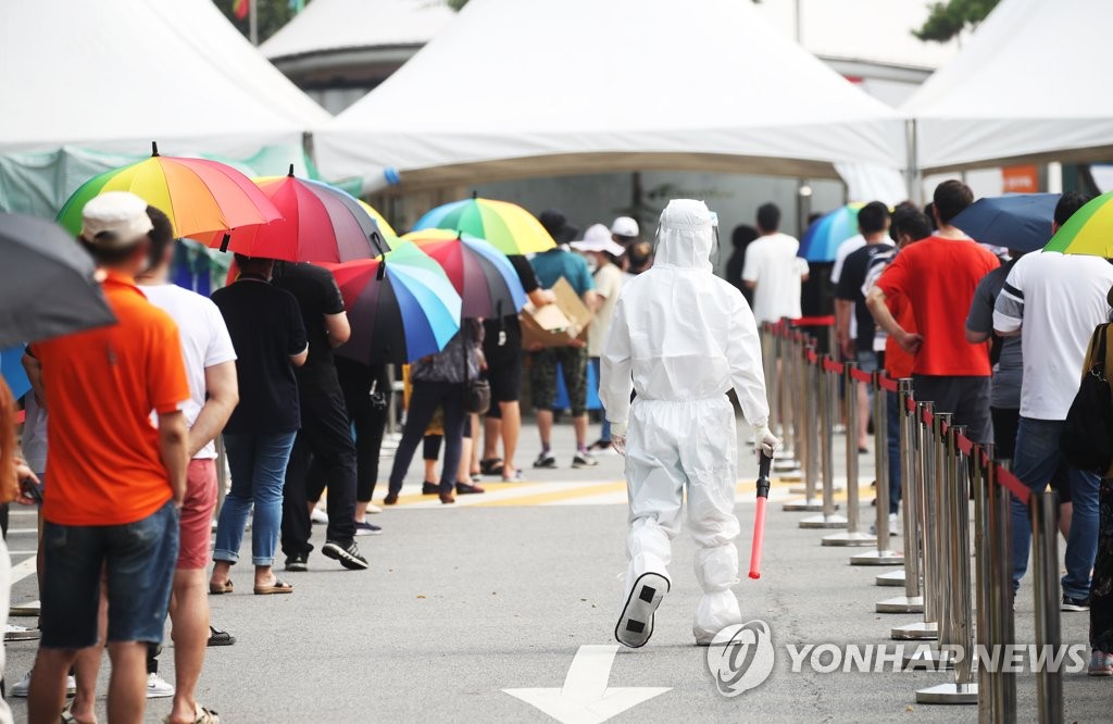 7月29日，在设于京畿道安山市檀园区外国人居民支援本部前的筛查诊所，市民排队等待核酸检测。 韩联社