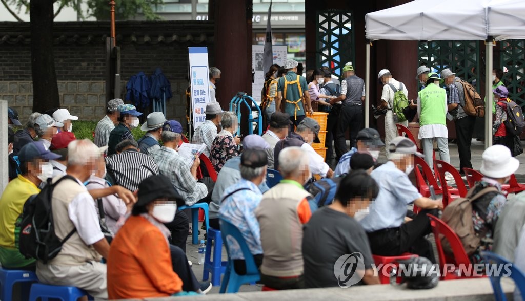 资料图片：图为老年人在首尔塔谷公园等待免费供餐，摄于2021年8月2日。图片与新闻内容无关。 韩联社