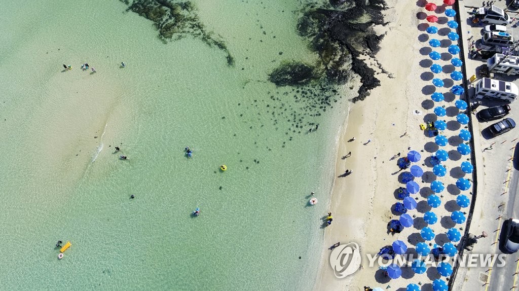 资料图片：2021年8月，在济州市翰林邑金陵海水浴场，游客们正避暑休闲。 韩联社