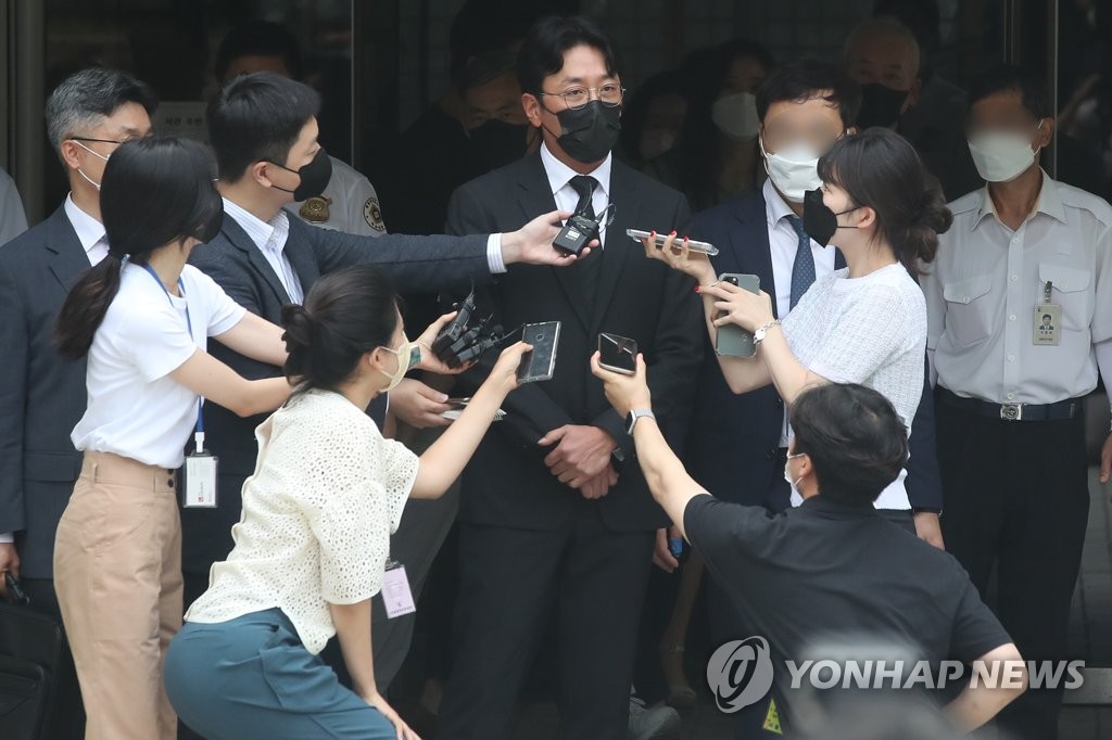 资料图片：8月10日，在首尔中央地方法院，演员河正宇（中）在出庭受审前答记者问。 韩联社
