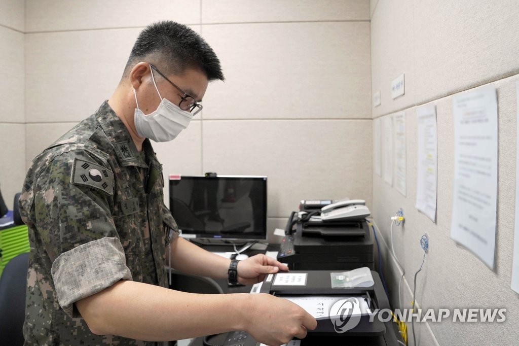 资料图片：7月27日，韩军一名工作人员利用西海地区军事通信线向朝方发送传真。 韩联社
