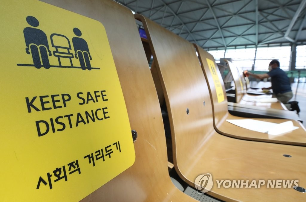 资料图片：8月11日，在仁川国际机场第一航站楼，椅子上贴着提醒保持社交距离的贴纸。 韩联社