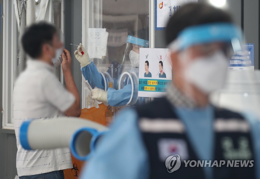 资料图片：8月13日，在设于首尔站广场的临时筛查诊所，市民接受病毒检测。 韩联社