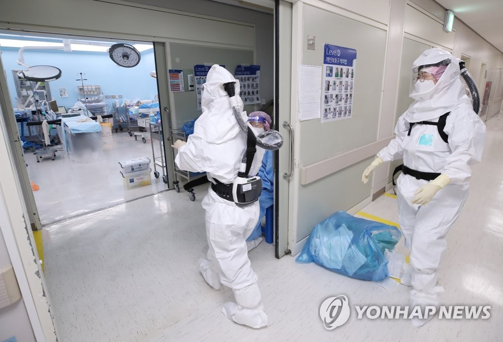 资料图片：身穿防护服的医务人员 韩联社