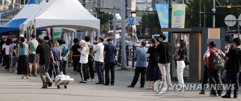资料图片：市民排队等候新冠检测核酸采样。 韩联社