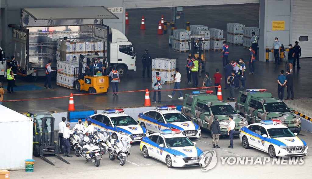 8月25日，在仁川国际机场货运航站楼，工作人员正在搬运到货的辉瑞新冠疫苗。 韩联社
