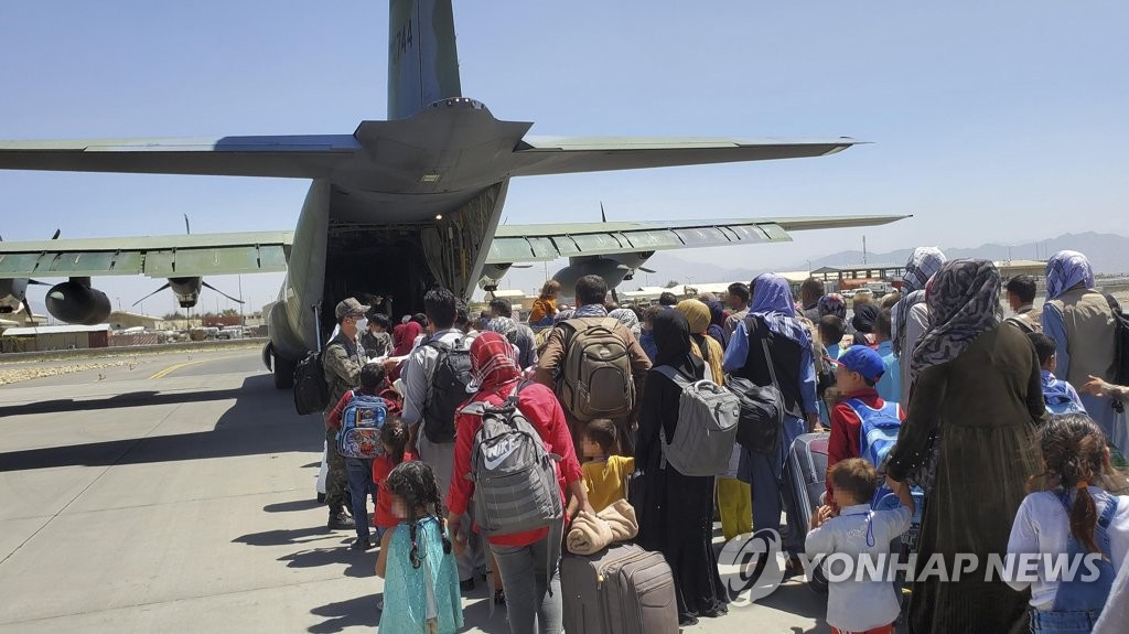 资料图片：8月25日，在阿富汗喀布尔机场，曾为韩国工作过的阿富汗人及其家属准备搭乘韩军运输机。 韩联社/韩国空军供图（图片严禁转载复制）