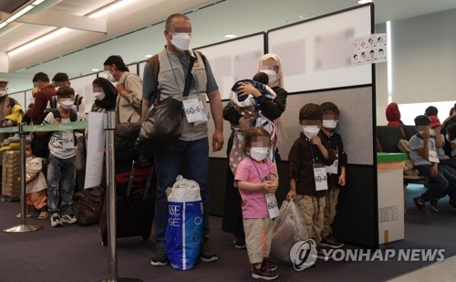 资料图片：8月26日，曾为韩国工作过的阿富汗人及其家属乘坐韩军运输机抵达韩国，等待接受病毒检测。 韩联社/联合摄影记者团