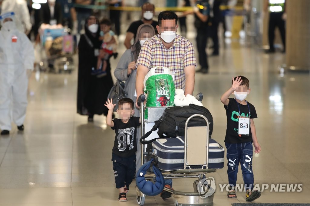 8月26日，在仁川国际机场，曾协助韩国政府活动的阿富汗人及其家属乘坐韩国空军多功能空中加油运输机抵达韩国。图为他们在接受核酸检测后，按照工作人员的指示走出机场。 韩联社