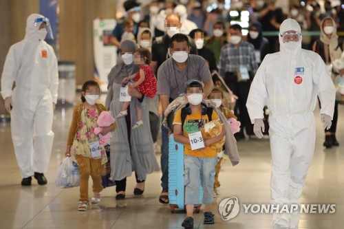 资料图片：8月26日，在仁川国际机场，第一批曾协助韩国政府活动的阿富汗人及其家属乘坐韩国空军多功能空中加油运输机抵达韩国。图为他们在接受核酸检测后，按照工作人员的指示走出机场。 韩联社