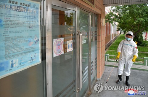 资料图片：朝鲜防疫人员在一所中学防疫消毒。 韩联社/朝中社（图片仅限韩国国内使用，严禁转载复制）