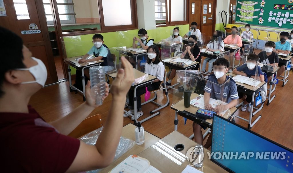 资料图片：9月8日，在庆尚南道金海市一小学，学生们戴口罩上课。 韩联社